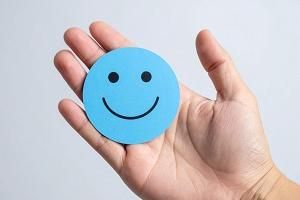 Eine Hand hält eine Smiley-Karte